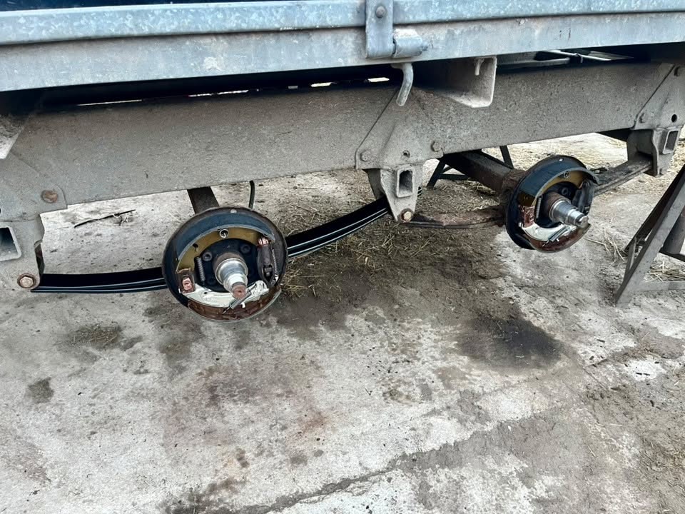 Twin-axle trailer brakes exposed for servicing