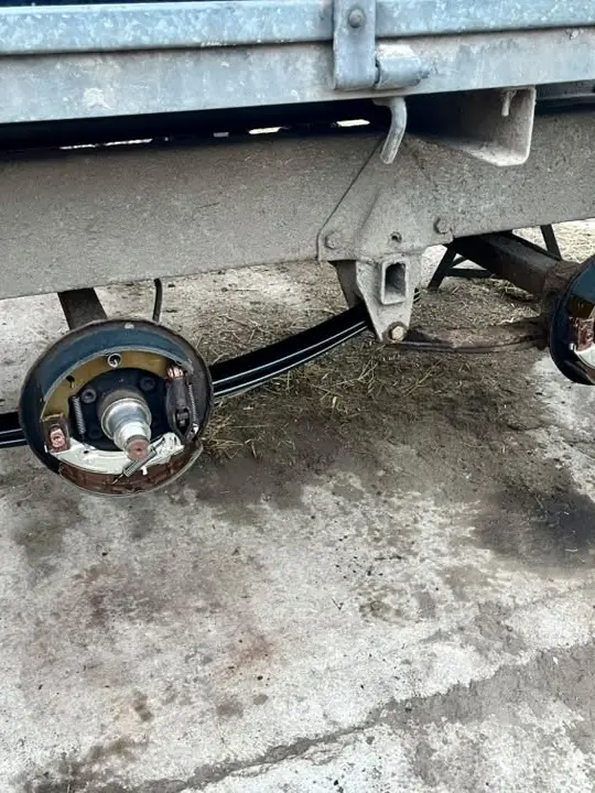 Twin-axle trailer brakes exposed for servicing